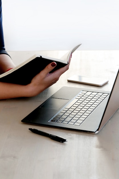 Foto grátis jovem mulher trabalhando com laptop e agenda