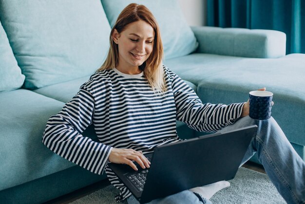 Jovem mulher trabalhando e estudando em seu laptop em casa