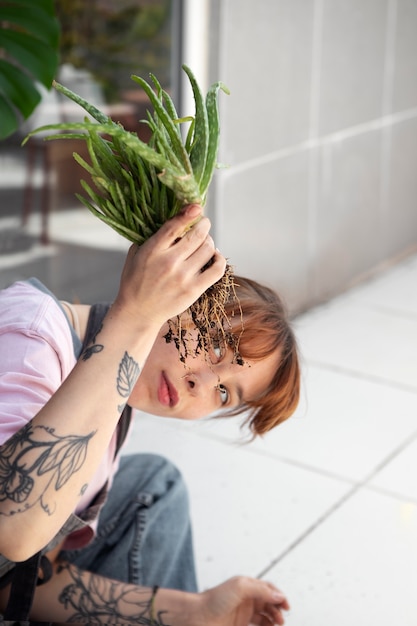 Foto grátis jovem mulher transplantando planta de alto ângulo