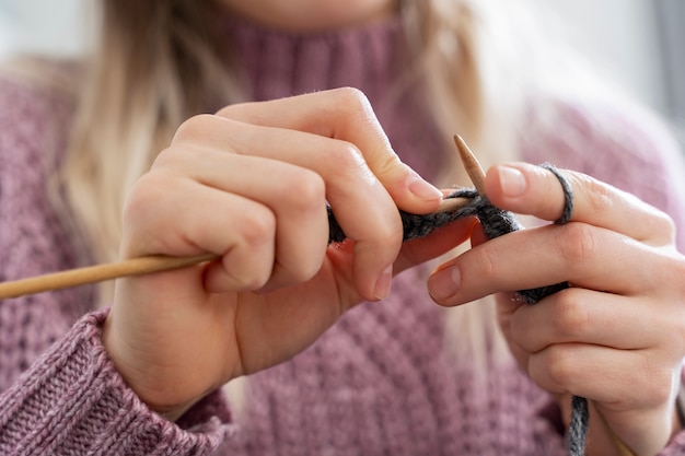 Jovem mulher tricotando enquanto relaxa