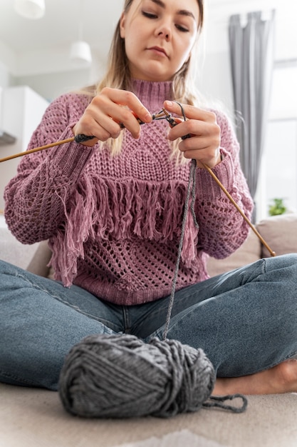 Foto grátis jovem mulher tricotando enquanto relaxa