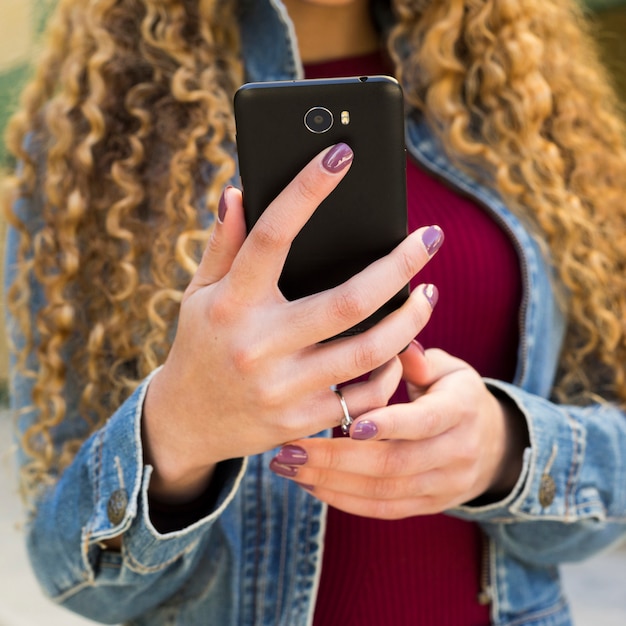 Foto grátis jovem mulher urbana olhando para smartphone