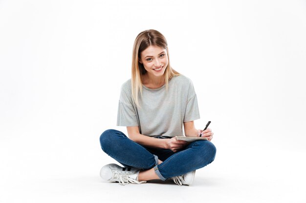 Jovem mulher usando lápis e caderno