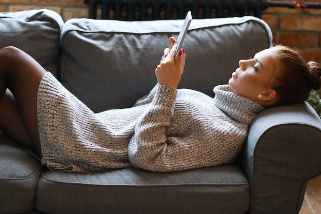 Jovem mulher usando tablet no sofá