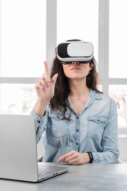 Foto grátis jovem mulher usando um fone de ouvido da realidade virtual