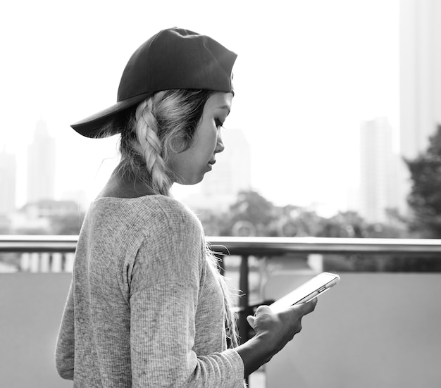 Jovem mulher usando um smartphone na paisagem urbana