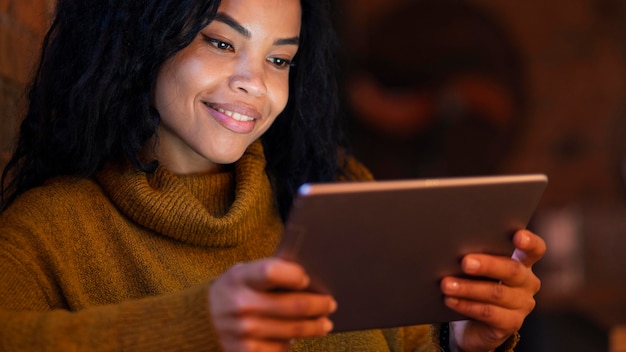 Foto grátis jovem mulher usando um tablet em uma cafeteria