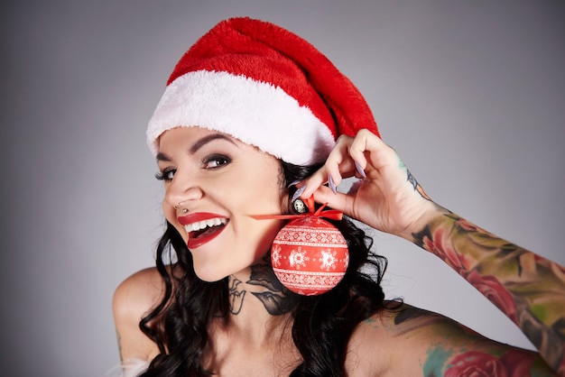 Foto grátis jovem mulher usando uma bola de natal como brinco