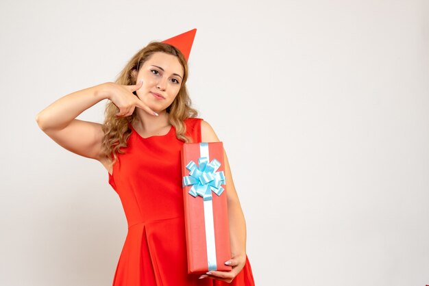 Jovem mulher vestida de vermelho celebrando o natal com um presente