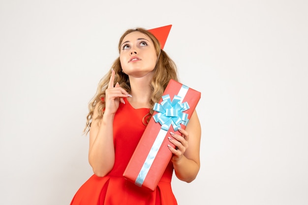 Jovem mulher vestida de vermelho celebrando o natal com um presente