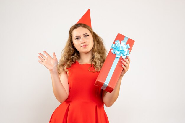 Jovem mulher vestida de vermelho celebrando o natal com um presente