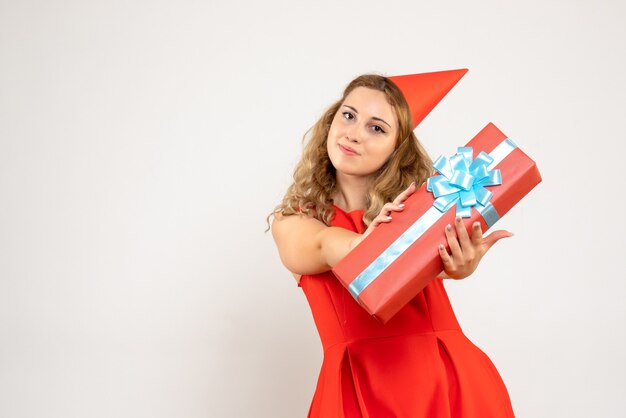 Jovem mulher vestida de vermelho celebrando o natal com um presente