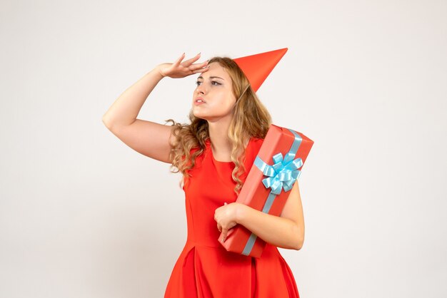 Jovem mulher vestida de vermelho celebrando o natal com um presente