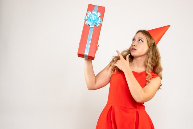 Jovem mulher vestida de vermelho celebrando o natal com um presente