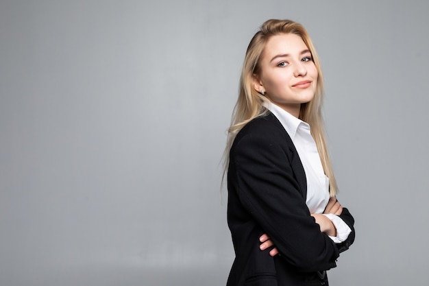 Foto grátis jovem mulher vestindo em pé com os braços cruzados, olhando com uma expressão séria isolada