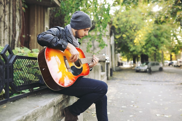 Jovem músico com guitarra na cidade