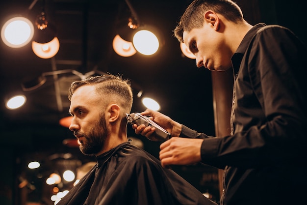 Jovem na barbearia aparando cabelo