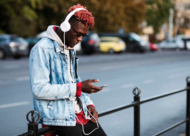 Foto grátis jovem na cidade, olhando para o telefone