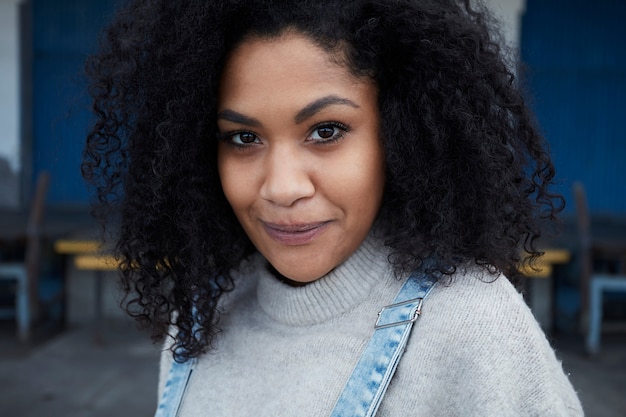 jovem negra com cabelo afro, rindo e curtindo