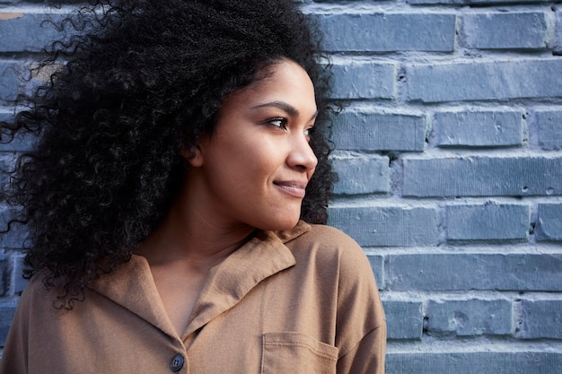 Jovem negra com cabelo afro, rindo e curtindo