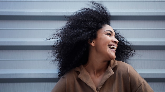 jovem negra com cabelo afro, rindo e curtindo