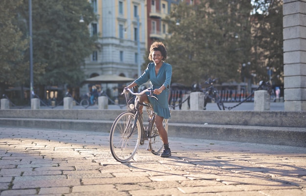 Jovem negra na cidade com bicicleta