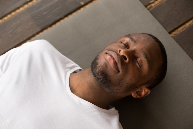 Jovem negro deitado no exercício do cadáver