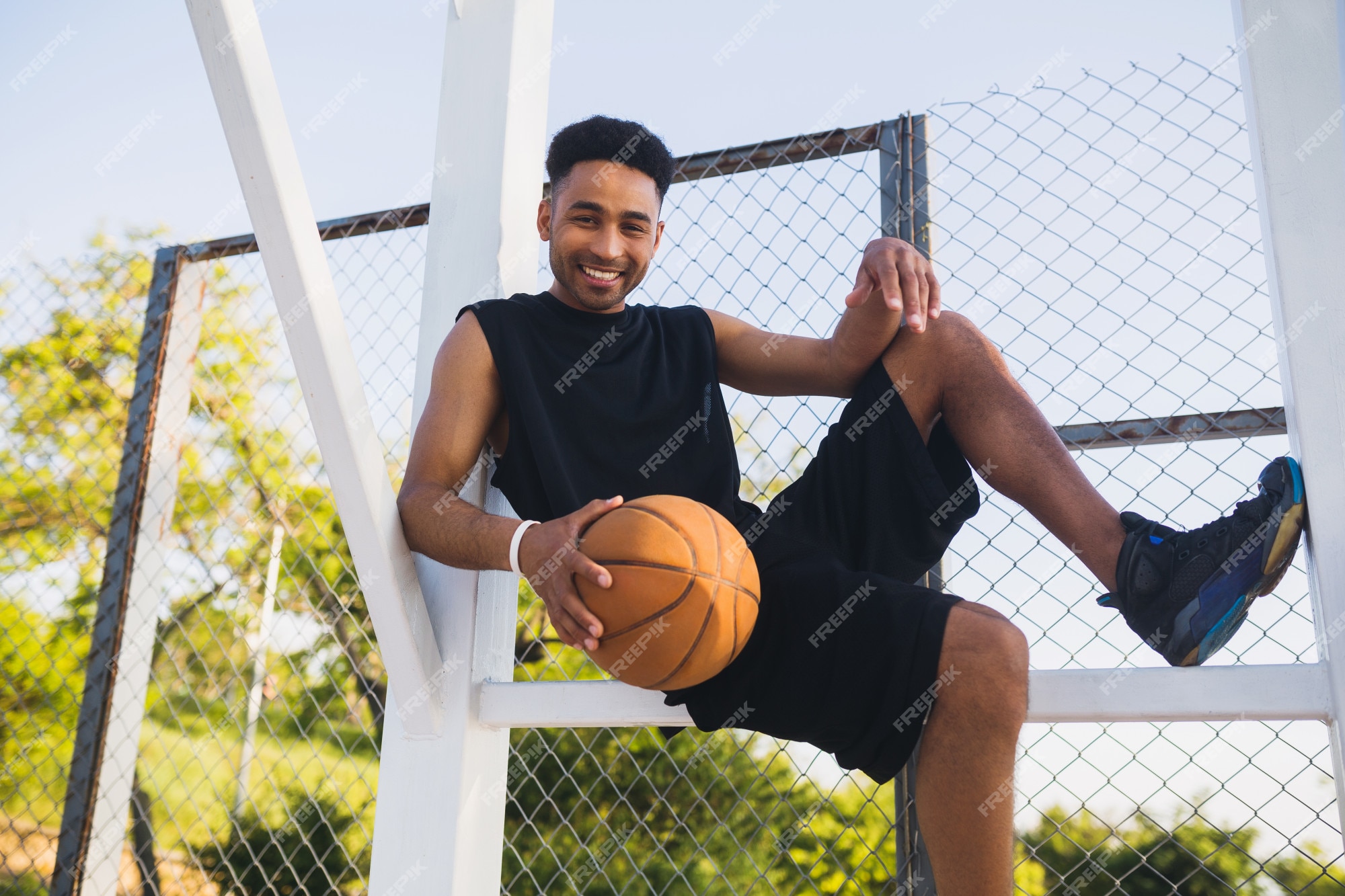 Jovem negro sorridente e feliz praticando esportes, jogando