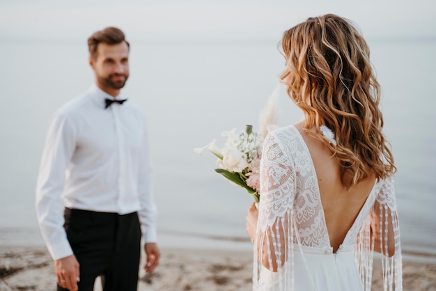 Jovem noiva e noivo fazendo um casamento na praia