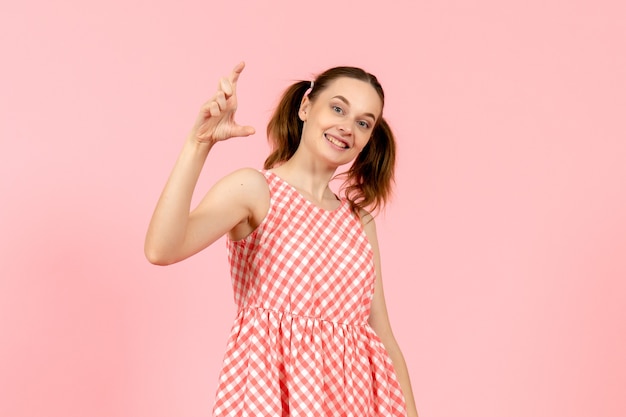 Jovem num lindo vestido rosa com expressão sorridente em rosa