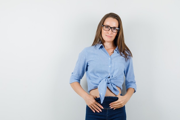 Foto grátis jovem olhando para a câmera e sorrindo de camisa azul