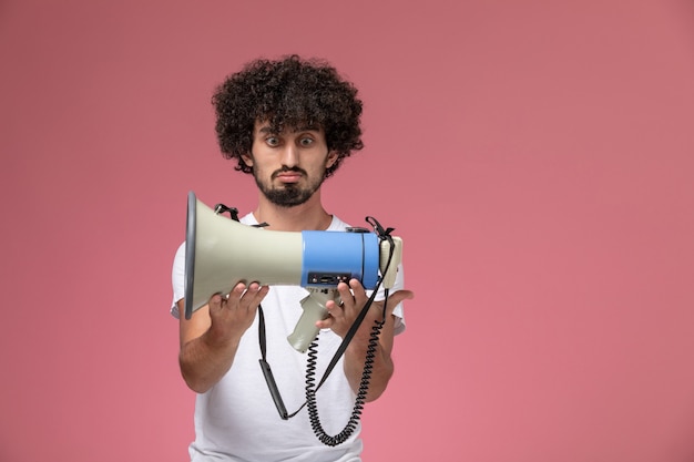 Jovem olhando para o microfone de mão com interesse