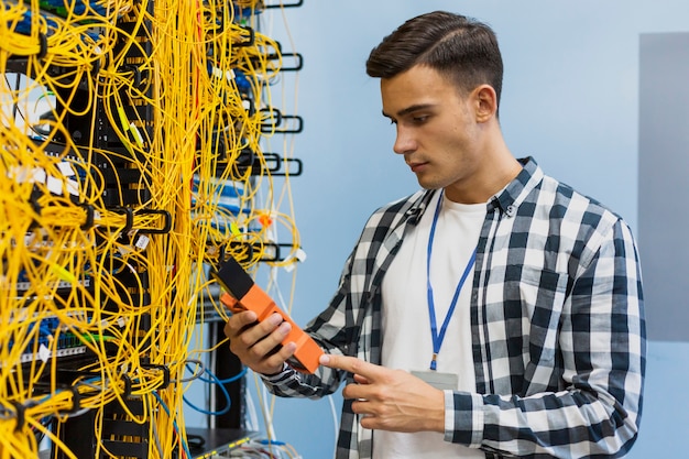 Jovem, olhando para o verificador médio de fibra óptica