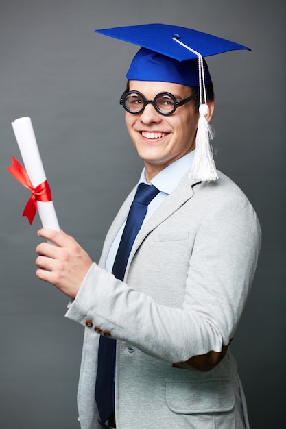 Foto grátis jovem orgulhoso com seu diploma