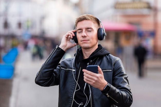 Jovem ouvindo música com os olhos fechados