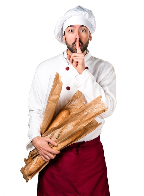 Jovem padeiro segurando um pouco de pão e fazendo um gesto de silêncio