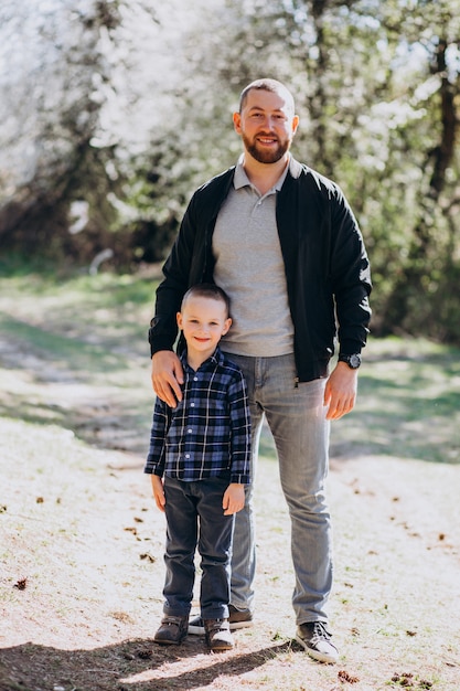 Jovem pai com filho pequeno na floresta