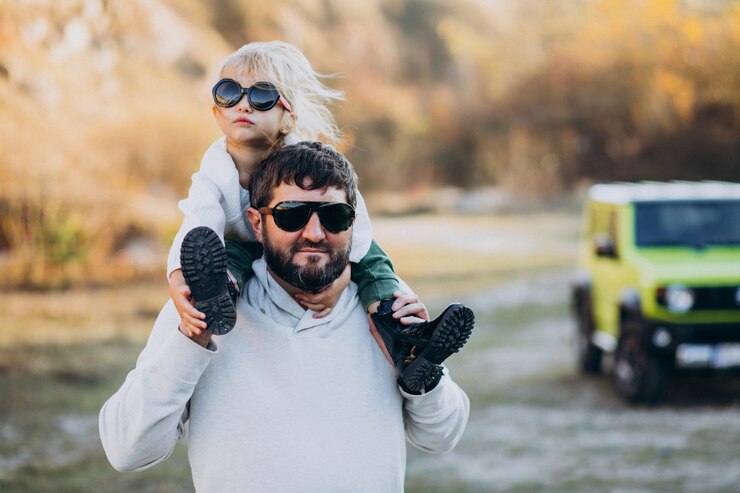Foto grátis jovem pai elegante com sua filha sentada nos ombros