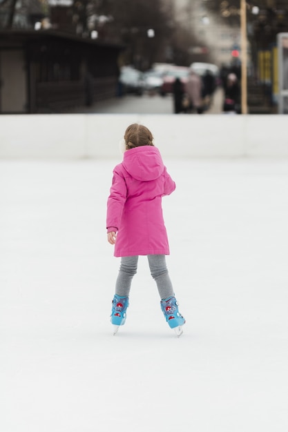 Foto grátis jovem patinação no gelo tiro traseiro