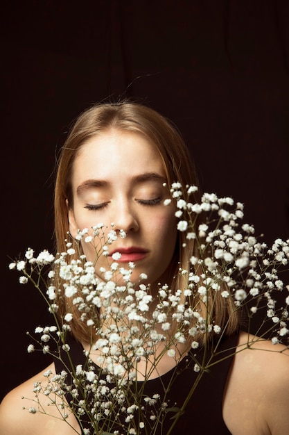 Jovem pensativa com flores brancas