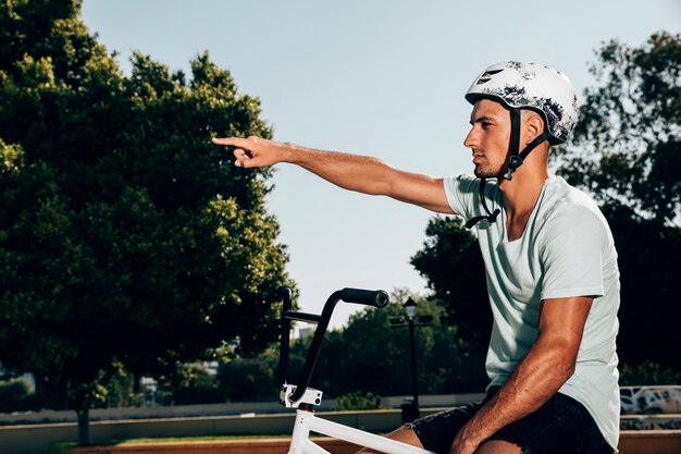 Jovem piloto de bmx em sua bicicleta, apontando o tiro médio