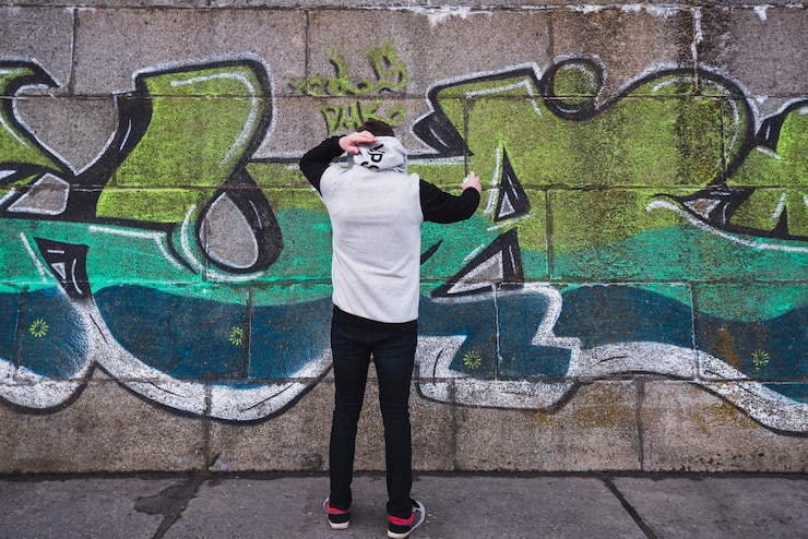 Foto grátis jovem pintor desenho grafite na parede
