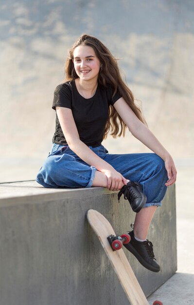 Foto grátis jovem posando ao lado de skate