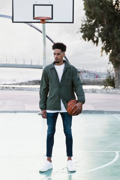 Jovem posando com bola de basquete