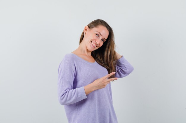 Jovem posando enquanto mostra o sinal de V com uma camisa casual e parece feliz