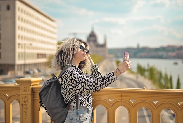 Foto grátis jovem posando para uma selfie em uma ponte