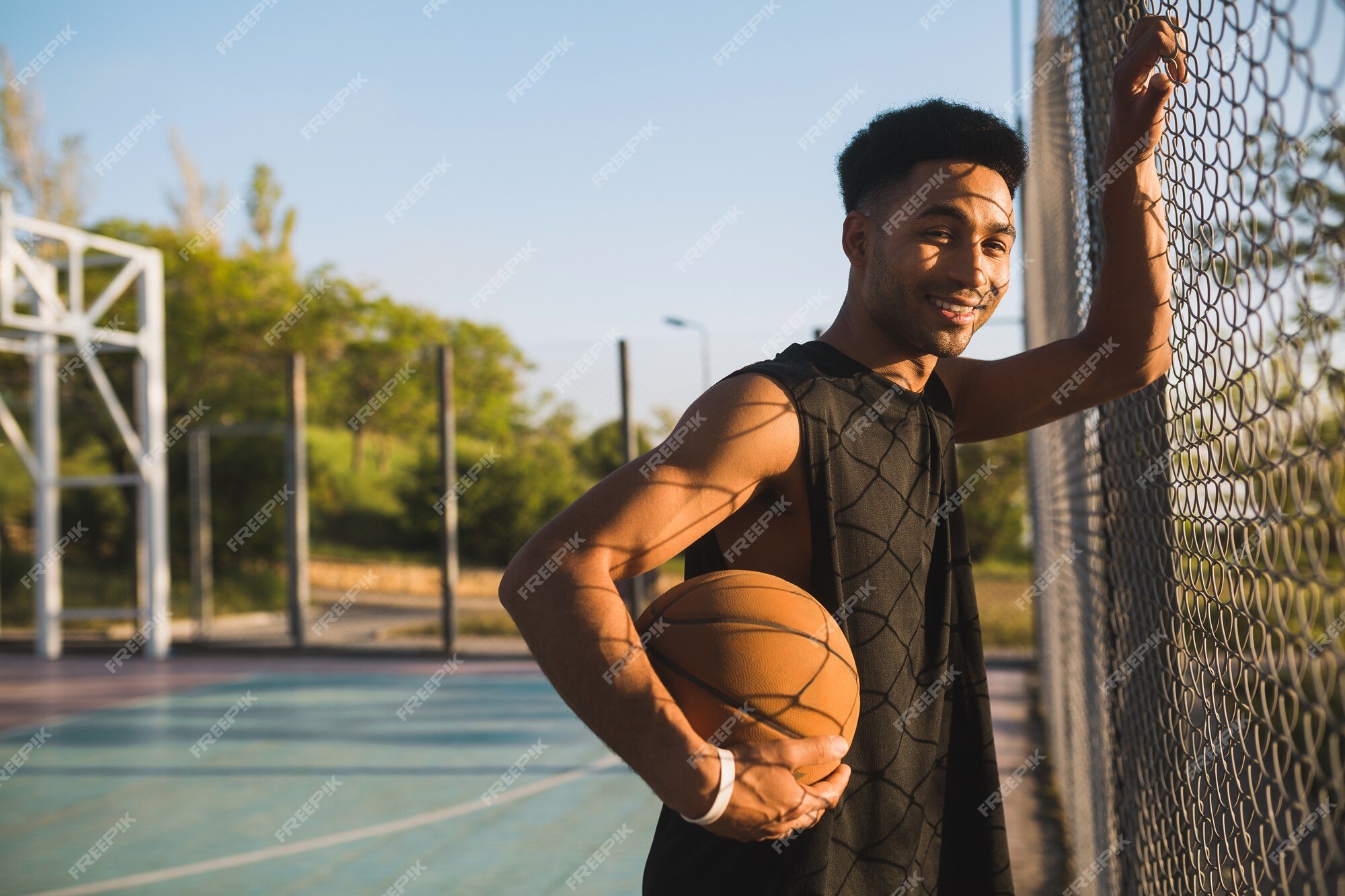 Jovem praticando esportes, jogando basquete ao nascer do sol