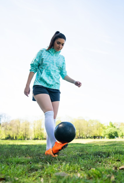 Jovem praticando futebol com bola