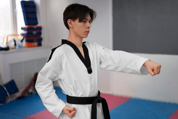 Foto grátis jovem praticando taekwondo em um ginásio