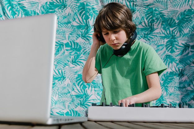 Jovem rapaz americano perto do controlador de dj - o conceito de djing